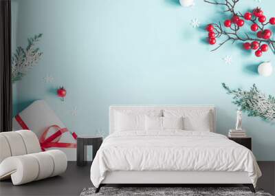 Christmas or winter composition. Frame made of gift, snowflakes, fir tree branches and red berries on pastel blue background. Christmas, winter, new year concept. Flat lay, top view, copy space Wall mural