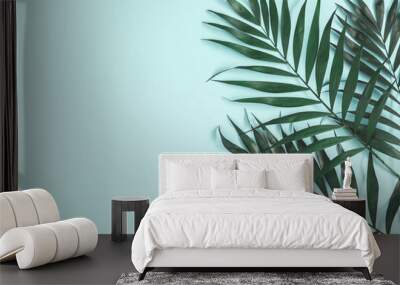 Palm leaves on pastel blue background. Summer concept. Flat lay, top view, copy space Wall mural