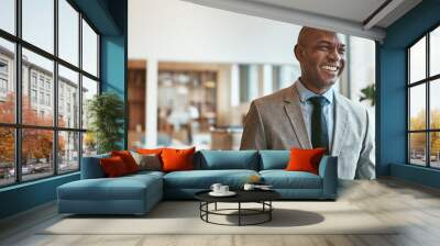 African American businessman laughing while walking through a modern office Wall mural