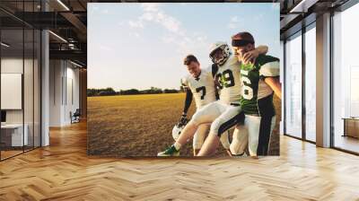 American football players carrying an injured teammate off the f Wall mural