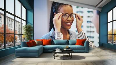 Attractive young African woman selecting glasses Wall mural