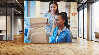 Beautiful young black woman waits to get eye exam Wall mural