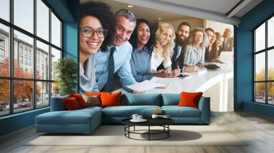 Cheerful multiracial colleagues looking at camera in office Wall mural