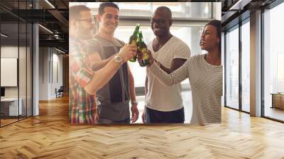 Cheerful people clanging beer bottles in office Wall mural