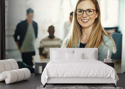 Confident young businesswoman smiling while standing in an office Wall mural