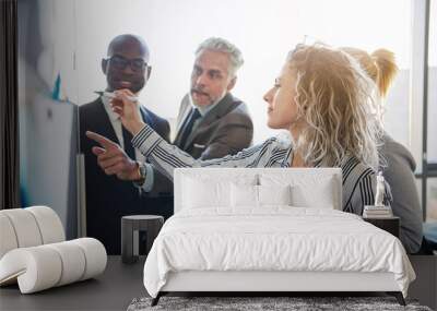 Corporate colleagues strategizing together on a whiteboard in an office Wall mural