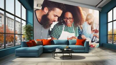 Couple making pasta dinner in kitchen with friends Wall mural