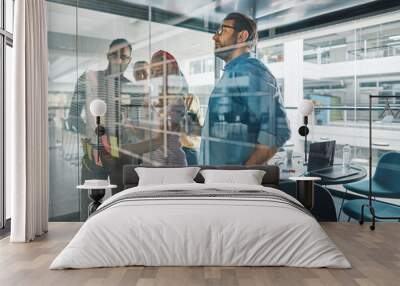 Diverse businesspeople brainstorming on a glass wall with sticky Wall mural