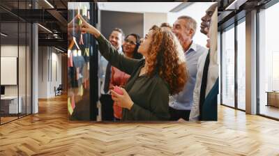 Diverse businesspeople brainstorming with sticky notes in an off Wall mural