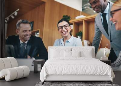 Diverse businesspeople laughing while going over paperwork in an Wall mural