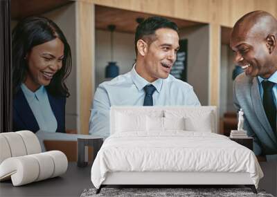 Diverse businesspeople smiling while working together at an office table Wall mural