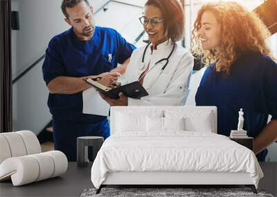 Diverse doctors discussing paperwork together in a hospital corr Wall mural