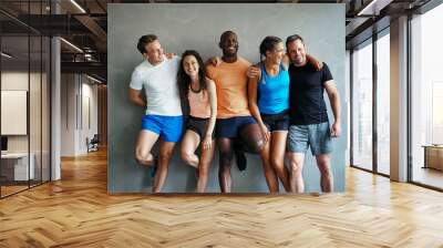 Diverse friends in sportswear laughing together in a gym Wall mural