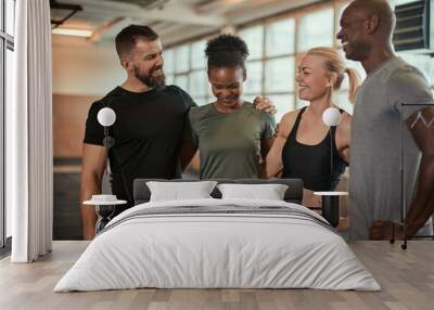 Diverse friends laughing after a workout together at the gym Wall mural