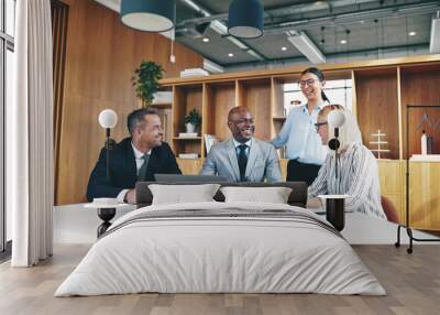 Diverse group of businesspeople laughing together around an offi Wall mural