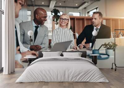 Diverse group of smiling businesspeople working around an office Wall mural