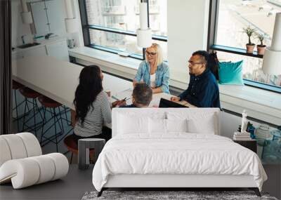 Diverse work colleagues meeting together around an office table Wall mural