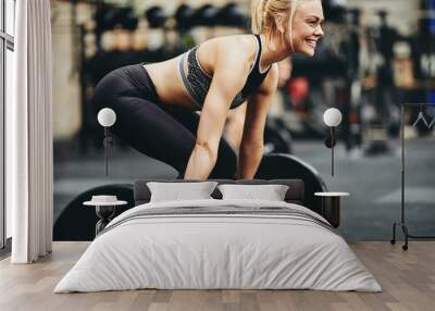 Fit young woman lifting heavy weights at the gym Wall mural