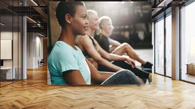 Fit young woman sitting with friends during a gym class Wall mural