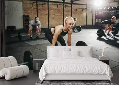 Fit young woman weightlifting during a gym class Wall mural