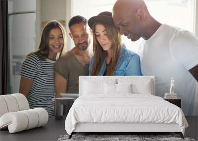 Four adults interested with something on tablet Wall mural