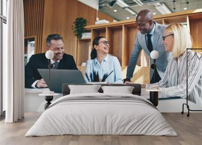 Group of diverse businesspeople laughing together during an offi Wall mural