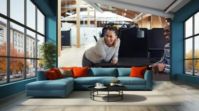 Group of young African American businesspeople laughing together during a casual meeting in a modern office. Wall mural