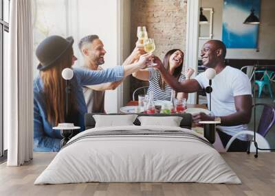 Happy adults toasting with drinks in restaurant Wall mural