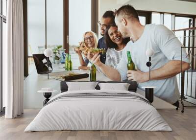 Laughing diverse office coworkers having pizza and beer after wo Wall mural