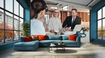 Laughing group of businesspeople working around an office table Wall mural