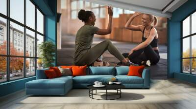 Laughing women high-fiving together after a workout Wall mural