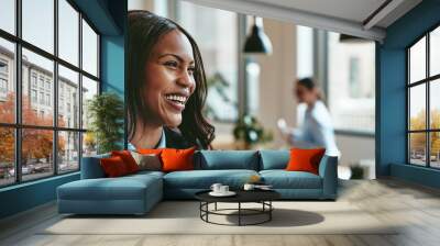 Laughing young African American businesswoman walking through an office Wall mural