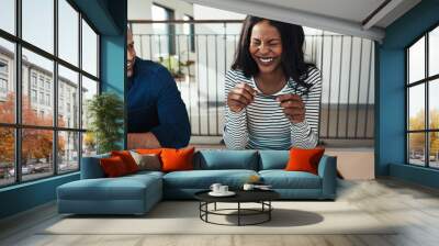 Laughing young businesswoman sitting with a colleague in an offi Wall mural