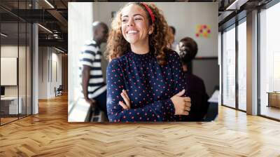 Laughing young designer standing in an office after a meeting Wall mural