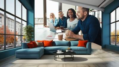 Mature businessman laughing with coworkers during an office meet Wall mural