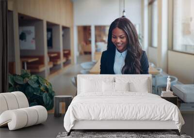 Smiling African American businesswoman using her laptop at a tab Wall mural