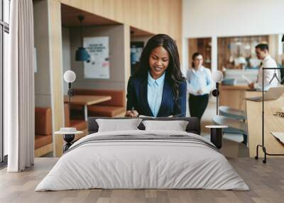 Smiling African American businesswoman walking through an office Wall mural