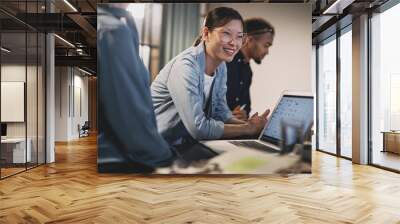 Smiling Asian businesswoman meeting with coworkers in an office Wall mural