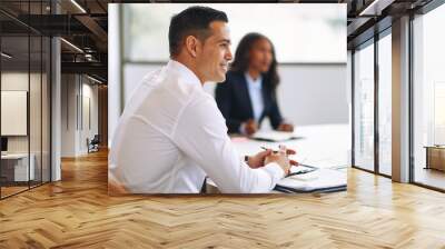 Smiling businessman sitting with colleagues during a boardroom m Wall mural