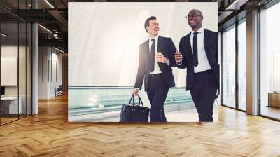 Smiling businessmen talking together while walking in an airport Wall mural