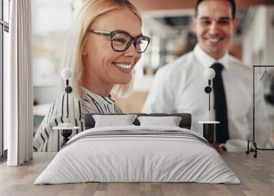 Smiling businesswoman talking with colleagues over coffee in an Wall mural