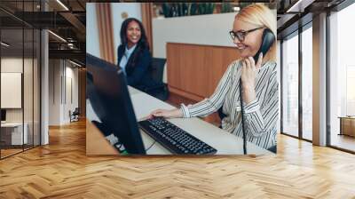 Smiling businesswoman working with a colleague at an office rece Wall mural