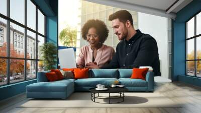 Smiling colleagues working online together at an office desk Wall mural