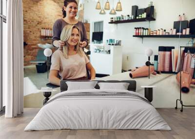 Smiling woman looking at her stylist in a salon mirror Wall mural