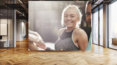 Smiling women sitting on a gym floor after working out Wall mural