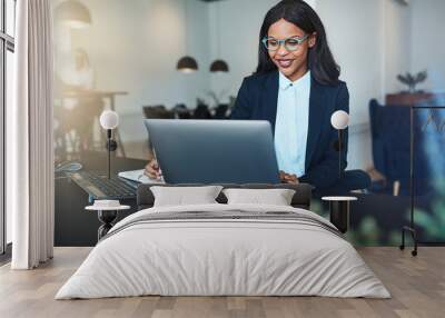 Smiling young African American businesswoman working in a modern Wall mural