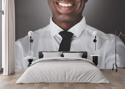 Smiling young African businessman standing against a gray backgr Wall mural