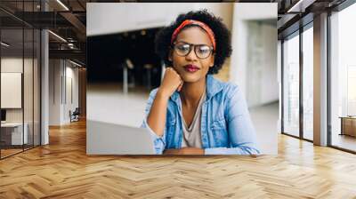 Smiling young African female entrepreneur working on her busines Wall mural