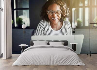 Smiling young African woman using a laptop Wall mural