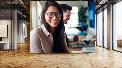 Smiling young Asian businesswoman sitting with colleagues in an office Wall mural